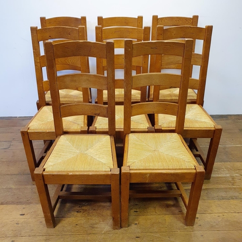 870 - An oak kitchen table, the top 180 x 87 cm, with two extra leaves, and a set of eight matching ladder... 