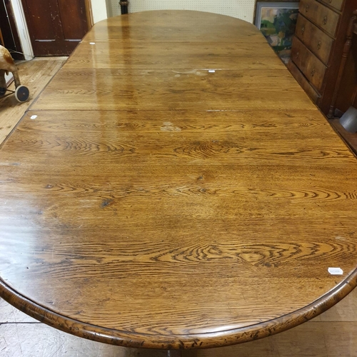 887 - An oak extending D end dining table, on twin pedestal supports, top 202 x 124 cm, with two extra lea... 