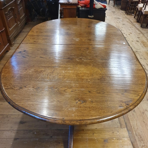 887 - An oak extending D end dining table, on twin pedestal supports, top 202 x 124 cm, with two extra lea... 