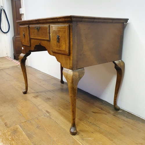 897 - A walnut lowboy, having three drawers, all raised on cabriole legs to pad feet, 91 cm wide