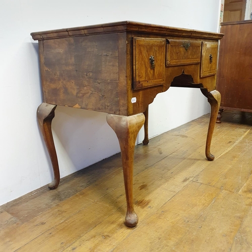 897 - A walnut lowboy, having three drawers, all raised on cabriole legs to pad feet, 91 cm wide