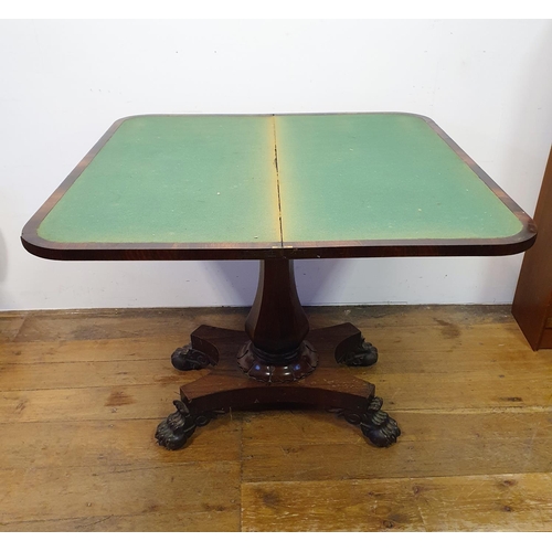 900 - A 19th century rosewood folding card table, on a column support to a shaped base, with lion paw feet... 