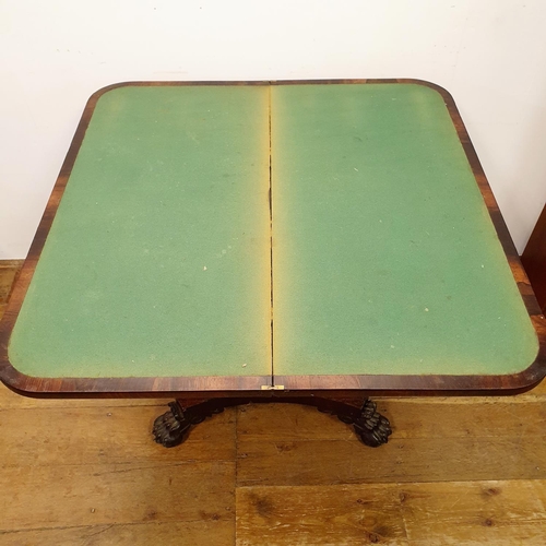 900 - A 19th century rosewood folding card table, on a column support to a shaped base, with lion paw feet... 