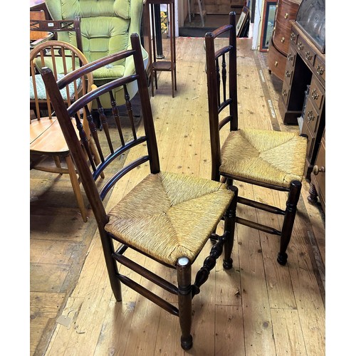 923 - A set of eight oak spindle back dining chairs, with rush seats, on turned legs to pad feet (7+1)