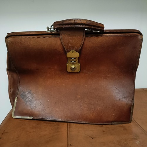 825 - A brown leather trunk, 91 cm wide, and three other cases (4)