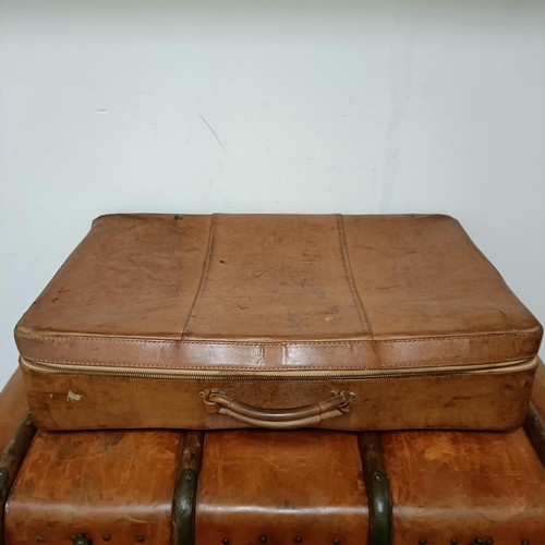 825 - A brown leather trunk, 91 cm wide, and three other cases (4)