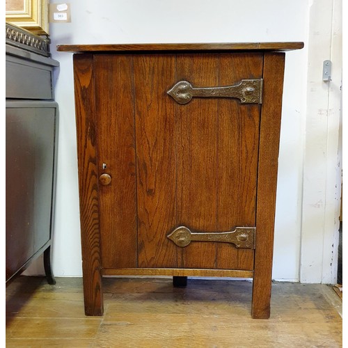 37 - An Arts and Crafts smokers oak corner cabinet, having a pair of wrought iron hinges, 53 cm high