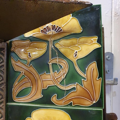 40 - An Art Nouveau style cast iron fire surround, inset with floral tiles, 83 cm high x 73 cm wide