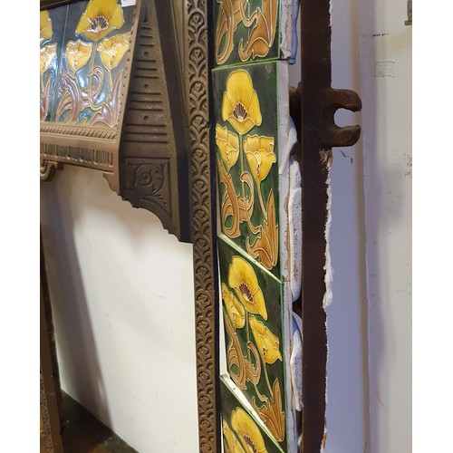 40 - An Art Nouveau style cast iron fire surround, inset with floral tiles, 83 cm high x 73 cm wide