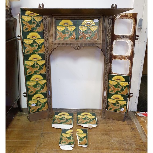 40 - An Art Nouveau style cast iron fire surround, inset with floral tiles, 83 cm high x 73 cm wide