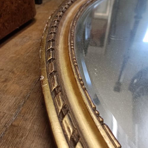 913 - An early 20th century gilt gesso oval wall mirror, 100 x 70 cm