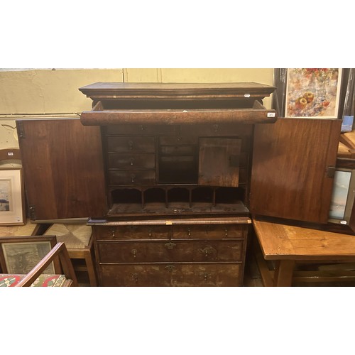 871 - An 18th century walnut cabinet on chest, the top with a drawer above two cupboard doors to reveal a ... 