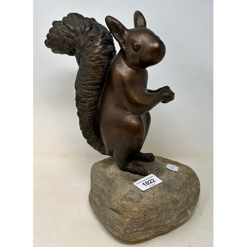 509 - A bronze squirrel, on a carved stone base, 32 cm high