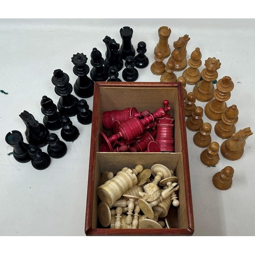 542 - A red stained and natural bone chess set, the king 11 cm high, and a black and natural wood chess se... 