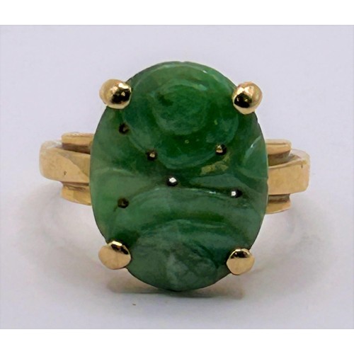 12 - A Chinese carved green stone ring, ring size L...