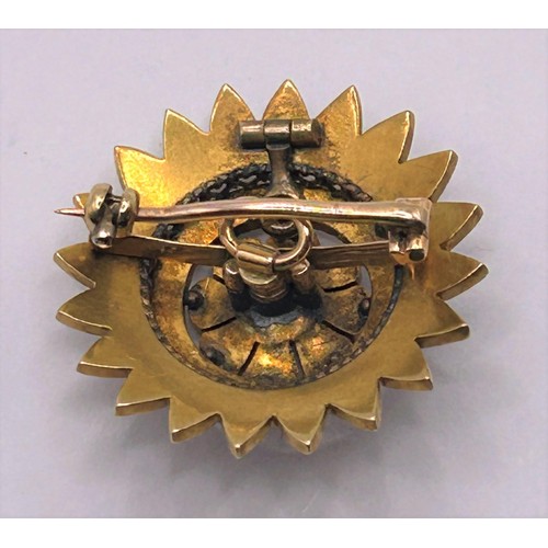 133 - An Edwardian yellow coloured metal and seed pearl target brooch, 3 cm diameter