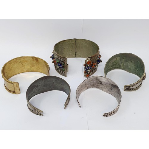 185 - An Indian silver coloured metal bangle, and four other bangles (5)