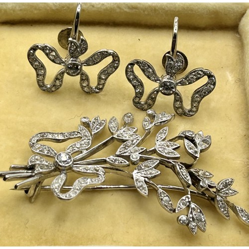 189 - ***Withdrawn*** An early 20th century white coloured metal and diamond bow and floral brooch, and a ... 