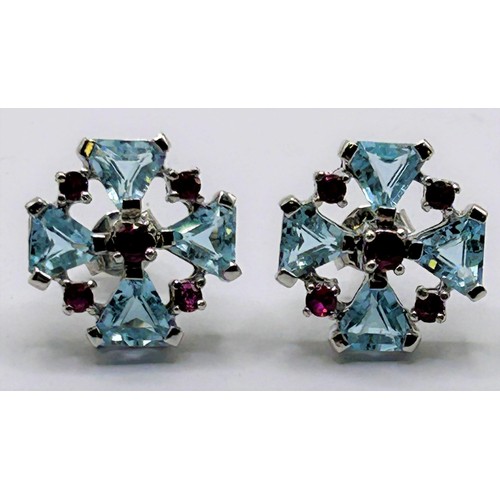 44 - A pair of silver coloured metal, topaz and ruby earrings...