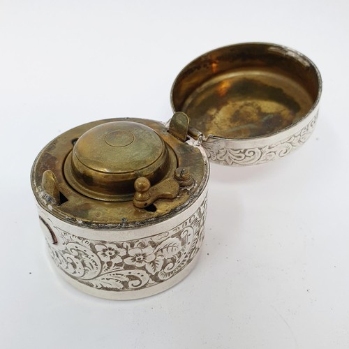 332 - A silver cased travelling inkwell, with embossed floral decoration, 4.5 cm diameter