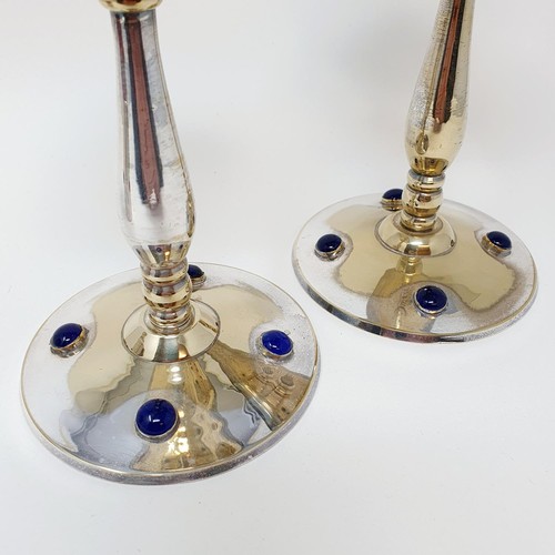 341 - A pair of silver plated candlesticks, the bases set with blue stones, 18 cm high, and a matching can... 