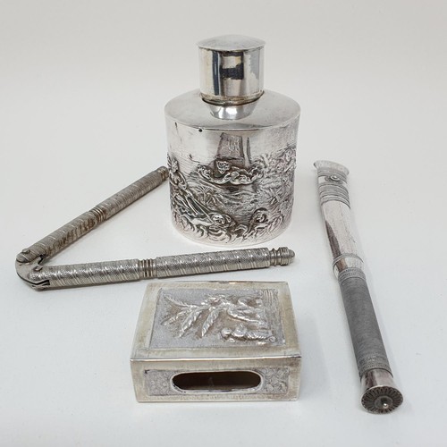 336 - A Dutch silver caddy, decorated a landscape and figures, a matchbox holder, a nutcracker, and an Eas... 