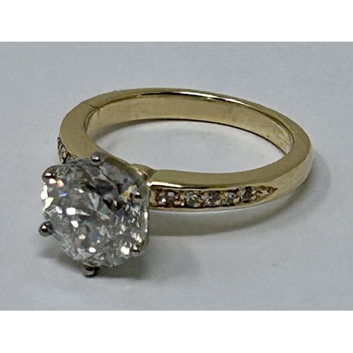 100 - A diamond solitaire ring, approx. 2.5ct, with a yellow coloured metal band,  set diamond shoulders, ... 