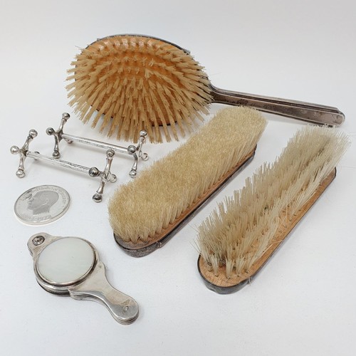 381 - A silver backed brush, two others, two silver plated knife stands, a magnifying glass, and a commemo... 