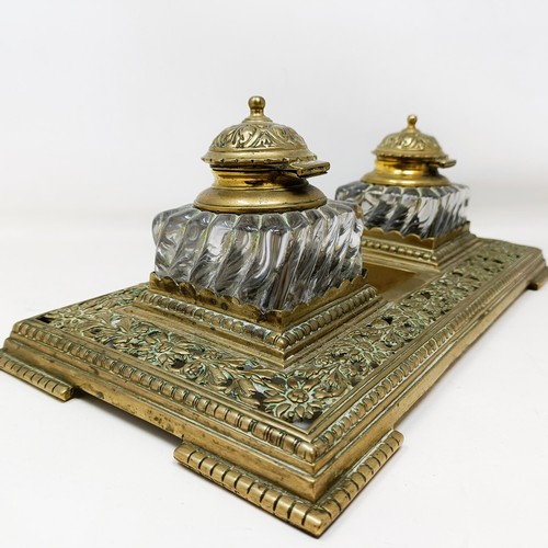 504 - An early 20th century brass inkstand, with a pair of glass inkwells, 36 cm wide