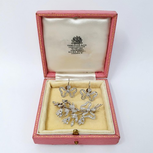 189 - ***Withdrawn*** An early 20th century white coloured metal and diamond bow and floral brooch, and a ... 