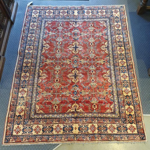 943 - A Persian red ground rug, multiple borders, centre with repeating geometric motifs, 226 x 179