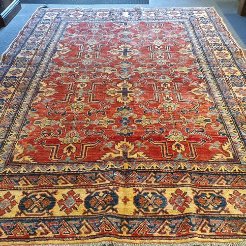 943 - A Persian red ground rug, multiple borders, centre with repeating geometric motifs, 226 x 179