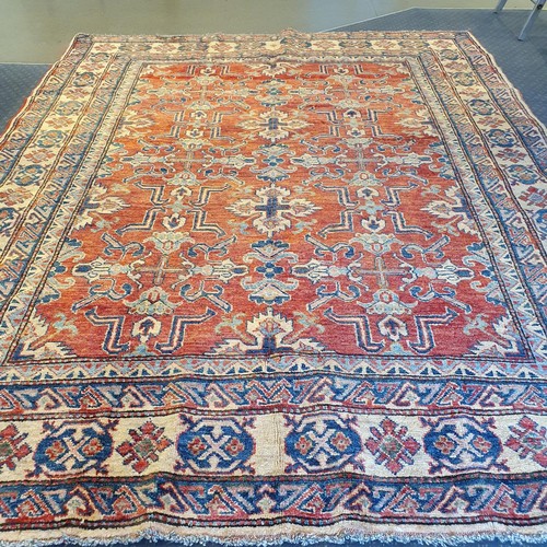 943 - A Persian red ground rug, multiple borders, centre with repeating geometric motifs, 226 x 179