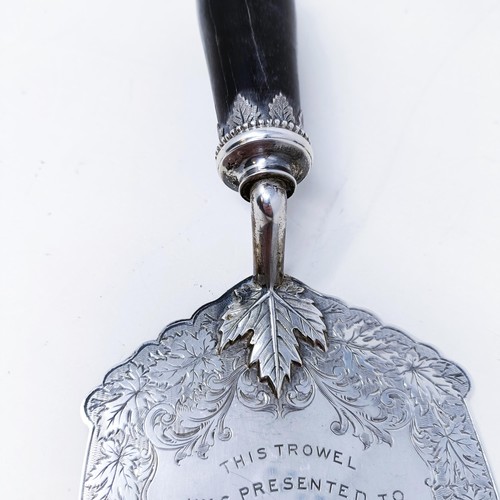 419 - A silver coloured metal ceremonial trowel with an ebonised handle, the finial in the form of a beave... 