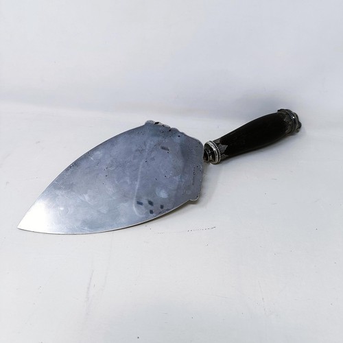 419 - A silver coloured metal ceremonial trowel with an ebonised handle, the finial in the form of a beave... 