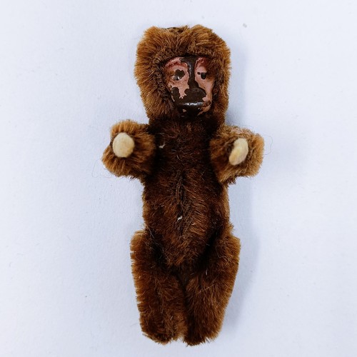 12 - A toy monkey, with a painted tin plate face, 8 cm