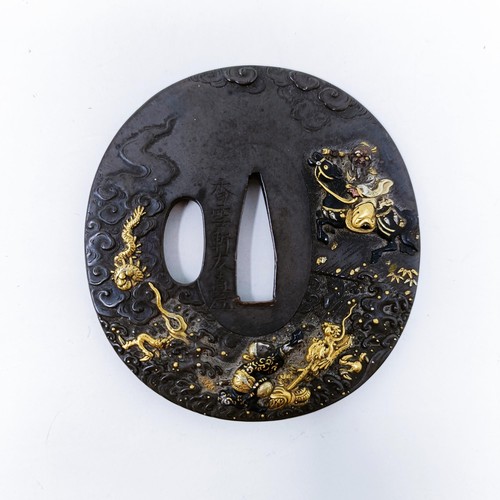 167 - A Japanese bronze tsuba, inlaid with gold, decorated a figure on horseback, and a dragon to one side... 