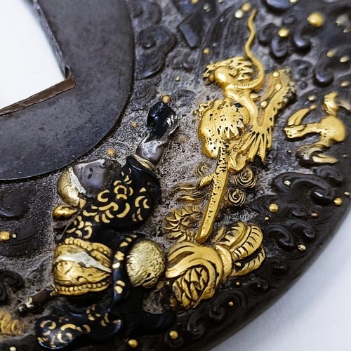 167 - A Japanese bronze tsuba, inlaid with gold, decorated a figure on horseback, and a dragon to one side... 