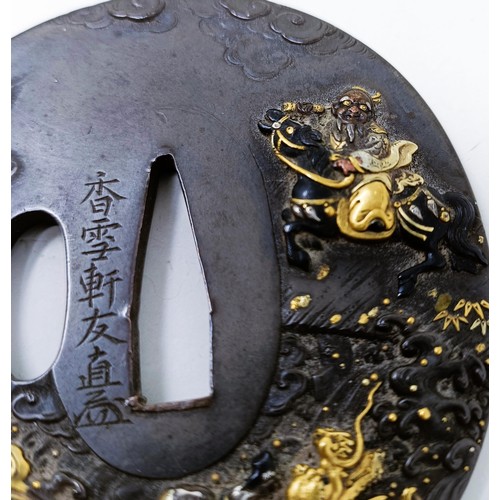 167 - A Japanese bronze tsuba, inlaid with gold, decorated a figure on horseback, and a dragon to one side... 