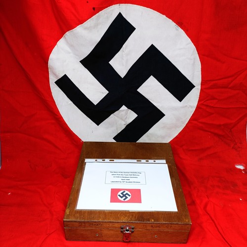 135 - A German Third Reich flag, with a swastika on a red ground, by family repute taken from town hall ba... 