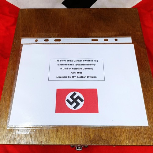 135 - A German Third Reich flag, with a swastika on a red ground, by family repute taken from town hall ba... 