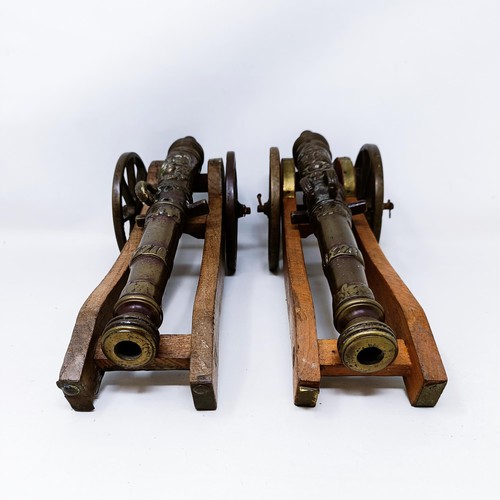 134 - A pair of Continental bronze table top cannons, drilled, the barrels 27 cm (2)