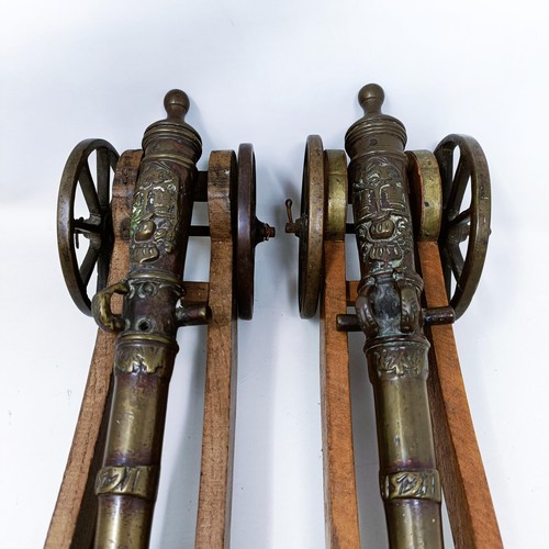 134 - A pair of Continental bronze table top cannons, drilled, the barrels 27 cm (2)