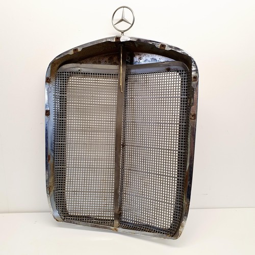 32 - A Mercedes-Benz chrome radiator surround, with an enamel badge and a three pointed star radiator cap... 