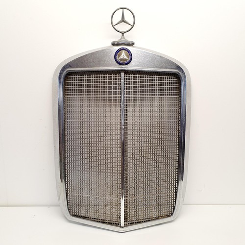 32 - A Mercedes-Benz chrome radiator surround, with an enamel badge and a three pointed star radiator cap... 