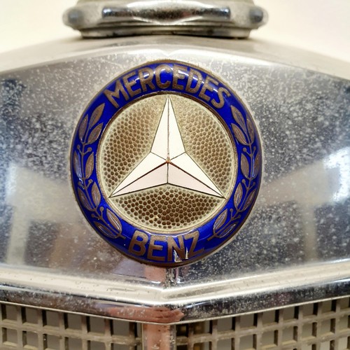 32 - A Mercedes-Benz chrome radiator surround, with an enamel badge and a three pointed star radiator cap... 