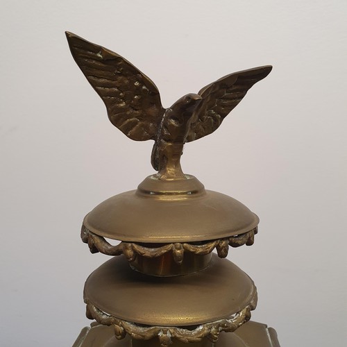 137 - An early 20th century brass oil carriage lamp, with an eagle finial, 59 cm high, mounted on a wooden... 