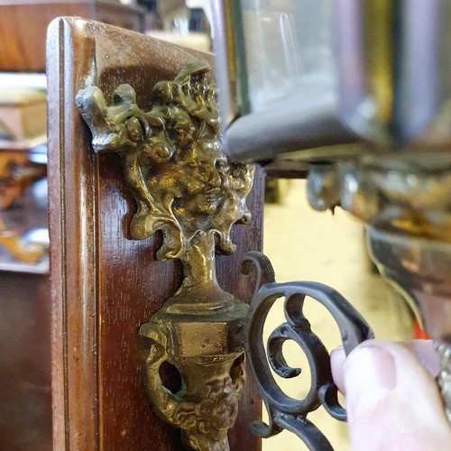 137 - An early 20th century brass oil carriage lamp, with an eagle finial, 59 cm high, mounted on a wooden... 