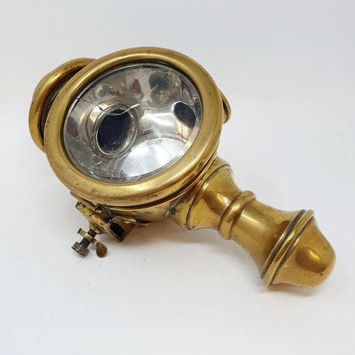 142 - An early 20th century brass oil sidelamp, lens cracked, 30 cm high