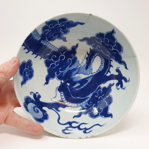 305 - A Chinese blue and white bowl, decorated dragon, six character mark to the base, 20 cm, and a shallo... 